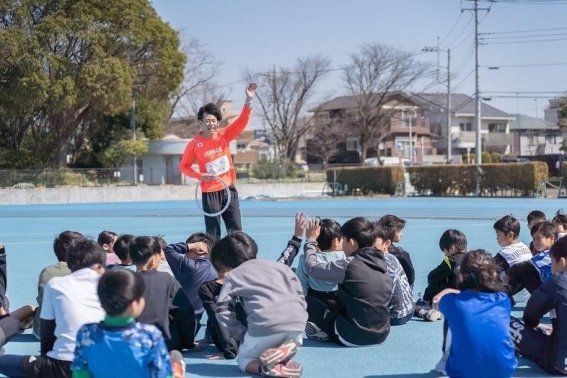 子どもたちの前で楽しく指導するコーチ