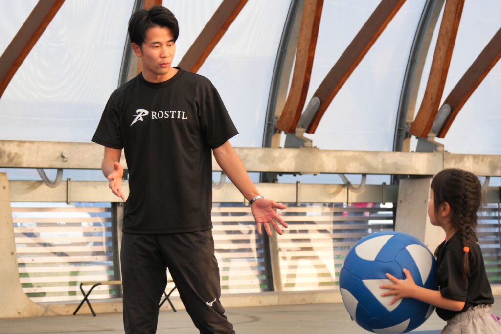 コーチが小学生に正しいフォームを丁寧に教える